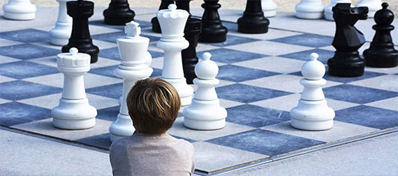 un enfant de dos face à un grand échiquier